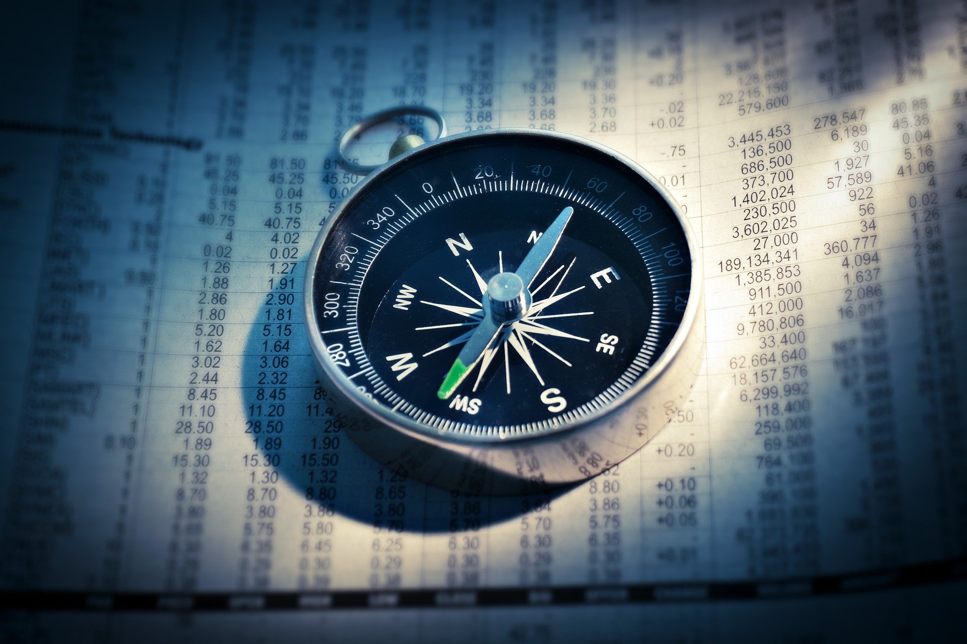 Printout of a spreadsheet with a compass lying on top