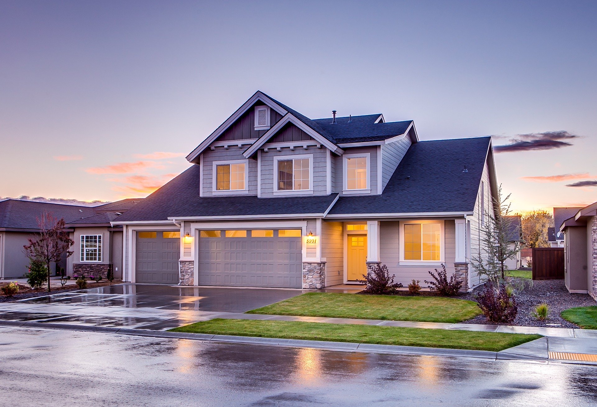 A beautiful and big home with a blue roof and yellow lights