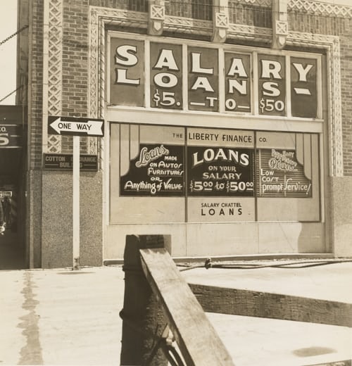 Side of building with a poster for salary loans, $5 to $50.